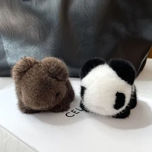Detailed texture of fluffy mink fur panda and bear charms on a luxury leather bag