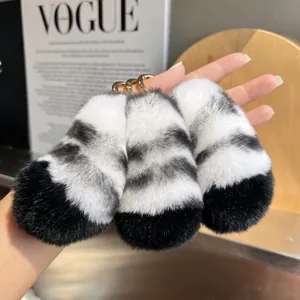 Close-up of fluffy black and white striped tiger tail fur keychains with gold hardware