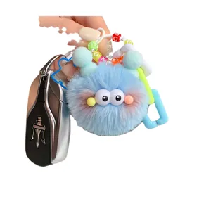Blue fuzzy pompom keychain with cartoon eyes and colorful letter bead charms