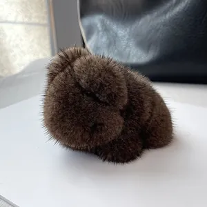 Close-up of fluffy mink fur panda charm with dense texture on a black leather bag