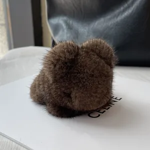 Close-up of deep brown mink fur bear pendant charm with soft texture on a bag