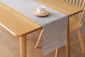 Λεπτομέρεια από μινιμαλιστικό PVC Runner τραπεζιού με γκρι υφαντή υφή σε ξύλο
