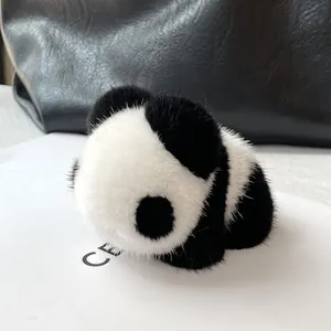 Luxury real mink fur panda bag charm with soft black and white plush hanging on a handbag