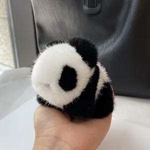 Hand holding a plush panda charm made of real mink fur for handbags and keychains