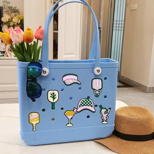 Light blue perforated beach tote bag with colorful PVC charms and summer accessories