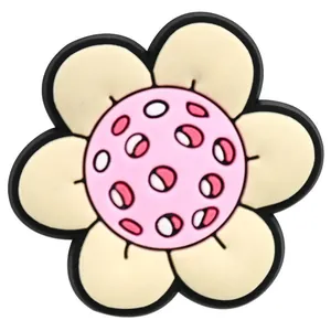 Detailed view of 3D PVC flower charm accessory for garden clogs in beige and pink