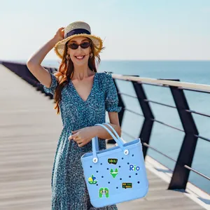 Hellblaue Strandtasche mit Brasilien-Fußball-Anhängern auf einem sonnigen Küstensteg