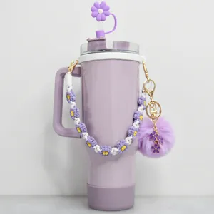 Détail du gobelet violet avec capuchon paille fleur, poignée tressée et pompon décor