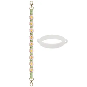 Détail du cordon tressé à fleurs roses avec fermoirs dorés et anneau de fixation en silicone