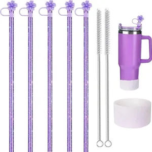 Dettaglio di cannucce viola glitterate con tappi a fiore di ciliegio e scovolino