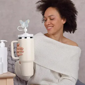 Detail view of a laser butterfly straw topper on a cream stainless steel tumbler