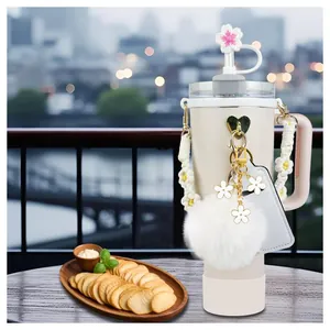 Cream 40oz tumbler with white floral handle cover and cherry blossom charm accessories