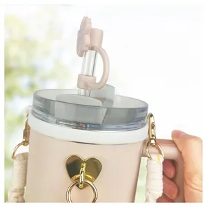 Pink tumbler set with floral straw topper, woven strap, and golden heart charm accent