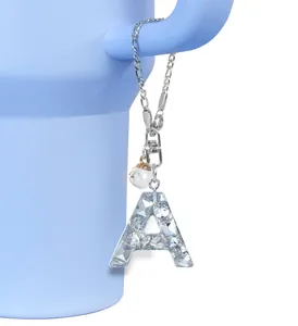 Κοντινό πλάνο με κρυστάλλινο γράμμα Α charm και ασημί κούμπωμα καβουράκι για τσάντες