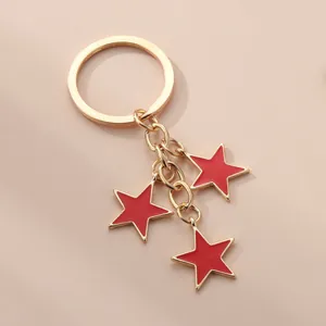 Porte-clés étoile rouge minimaliste avec trois breloques dorées et finition émail