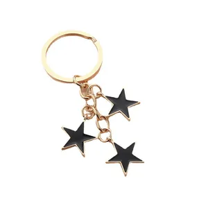 Détail du porte-clés étoile en métal doré avec des pendentifs en émail noir finis