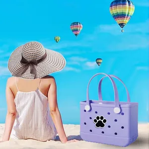 Sac de plage en EVA violet avec breloque patte de chien sur une plage de sable fin