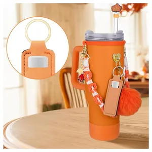 Detail of orange tumbler accessories set including paracord handle and maple straw cover