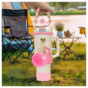 Off-white 40oz tumbler with pink floral handle, straw cover, and decorative charms set
