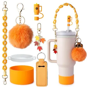 Detail of autumn-themed silicone straw cover, daisy braided handle, and fur ball pendant