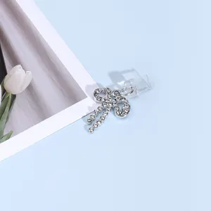 Vue macro de clips d'oreilles en forme de nœud argenté avec strass scintillants