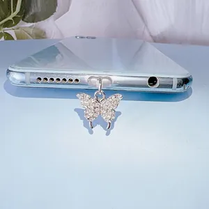 Bouchon anti-poussière papillon argenté avec pierres de zircon sur fond bleu clair