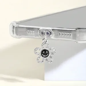 Vue macro d'un bijou de téléphone floral en argent avec strass et motif sourire
