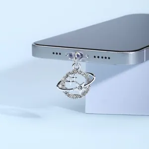 Vue macro du pendentif planète Saturne argenté avec zircons pour port de charge mobile