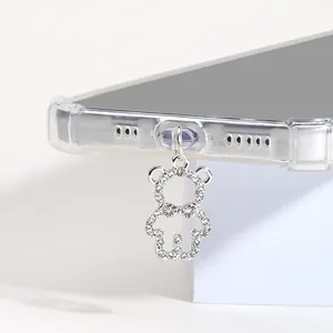 Vue macro d'un bijou d'ours en strass argenté fixé au port de charge du téléphone