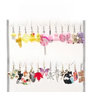 Detailed display of colorful cartoon earrings set on a white tiered jewelry stand