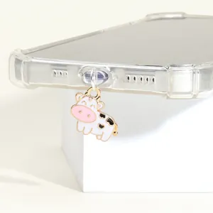 Gros plan détaillé d'un joli pendentif de téléphone vache en métal sur une coque transparente