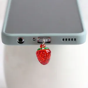 Gros plan du pendentif fraise pour port de charge avec feuilles vertes sur smartphone