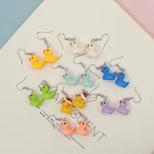 Close-up of colorful resin duck earrings in various shades with silver metal hooks