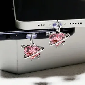 Bouchon anti-poussière rose en cristal avec anneau de planète argenté et petite flèche
