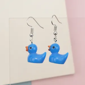 Detailed close-up of handmade blue resin duck earrings with silver hooks for students