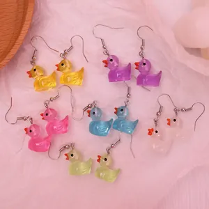 Detail showing six colorful resin duck earrings in yellow, pink, blue and purple