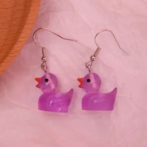 Detailed macro view of cute purple resin duck earrings with silver metal hooks