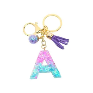 Porte-clés lettre A en résine pailletée dégradé rose et bleu avec pompon violet élégant
