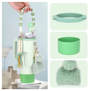 Mint green stainless steel tumbler with daisy woven strap and floral charm accessories