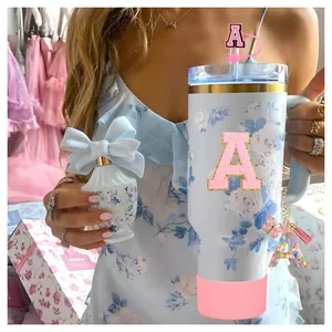 Pink floral 40oz tumbler set with straw topper, glitter letter charm, and silicone boot