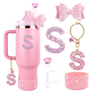 Close-up of pink glitter bow topper and rhinestone letter charm for Stanley cup