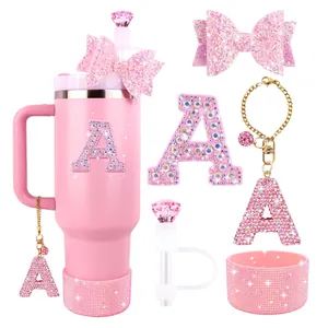 Pink tumbler set with bow straw cover, rhinestone letter A charms, and glitter silicone boot