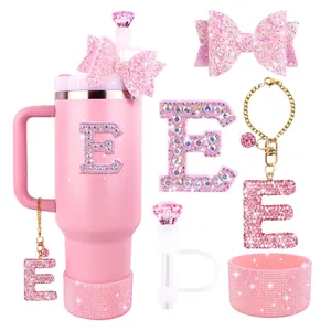 Close-up of pink glitter bow and rhinestone initial charm set on straw cover