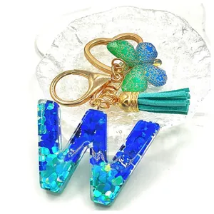 Portachiavi lettera W in resina con paillettes blu, anello a cuore e nappa
