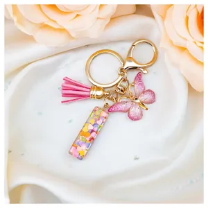 Resin initial keychain with pink tassel, butterfly charm and heart sequins