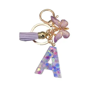 Porte-clés lettre A en résine violette avec boucle dorée, pompon et breloque papillon élégante