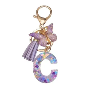 Porte-clés lettre C en résine avec fleur violette, paillettes, papillon et pompon