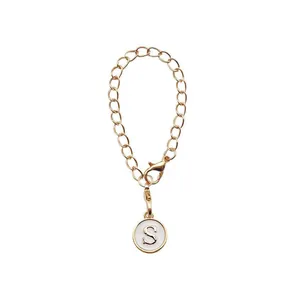 Porte-clés doré avec lettre initiale S et fermoir mousqueton sur fond blanc neutre