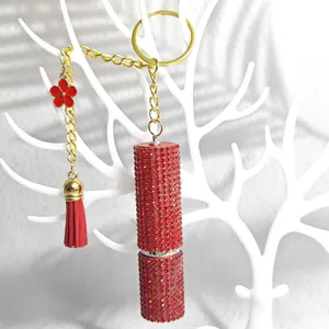 Detail of red rhinestone lipstick keychain with flower pendant and tassel decoration