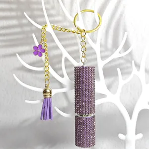 Detailed view of purple rhinestone perfume bottle keychain with tassel and gold chain